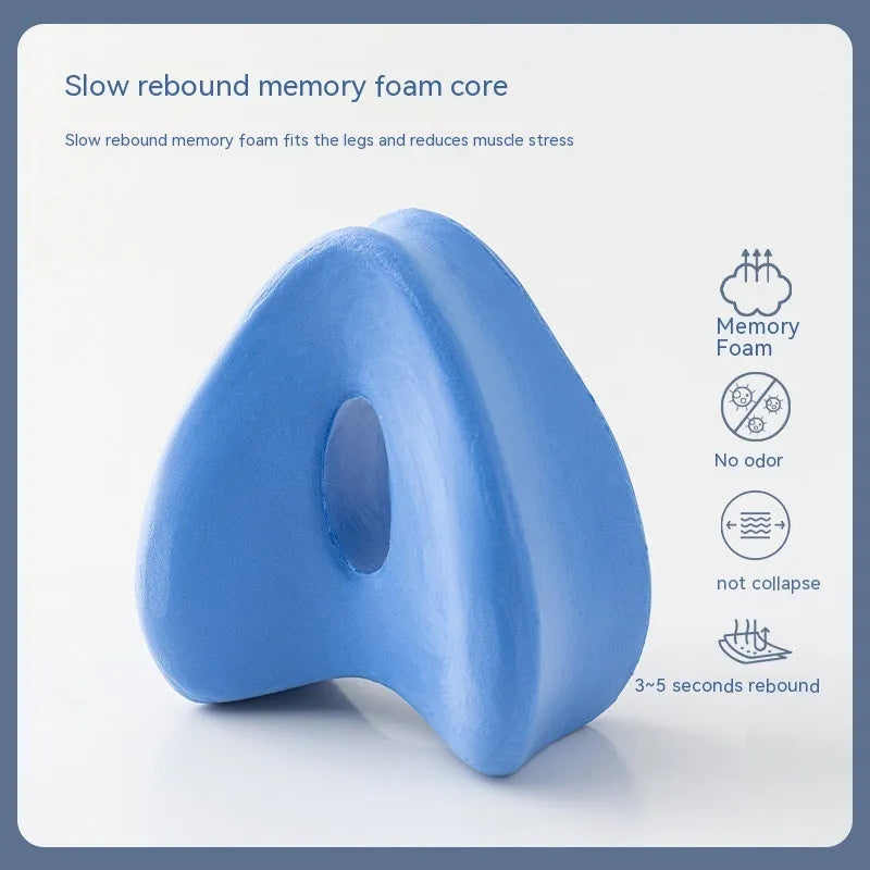 Love heart-shaped dark blue memory foam leg pillow for adults on a bed.