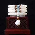 White jade Bodhi bead long bracelet with 6x8mm beads in various styles including cloisonne and tassel designs.