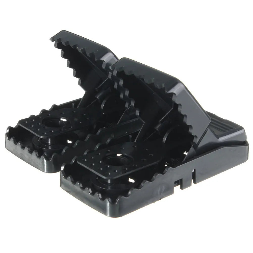 Six black plastic snapping mousetraps showing size and smooth surface.