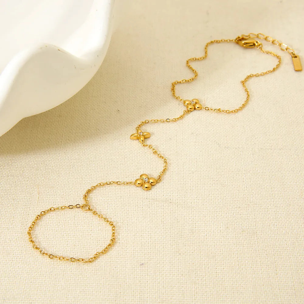 Gold stainless steel women's bracelet with geometric flower and eight-pointed star design.