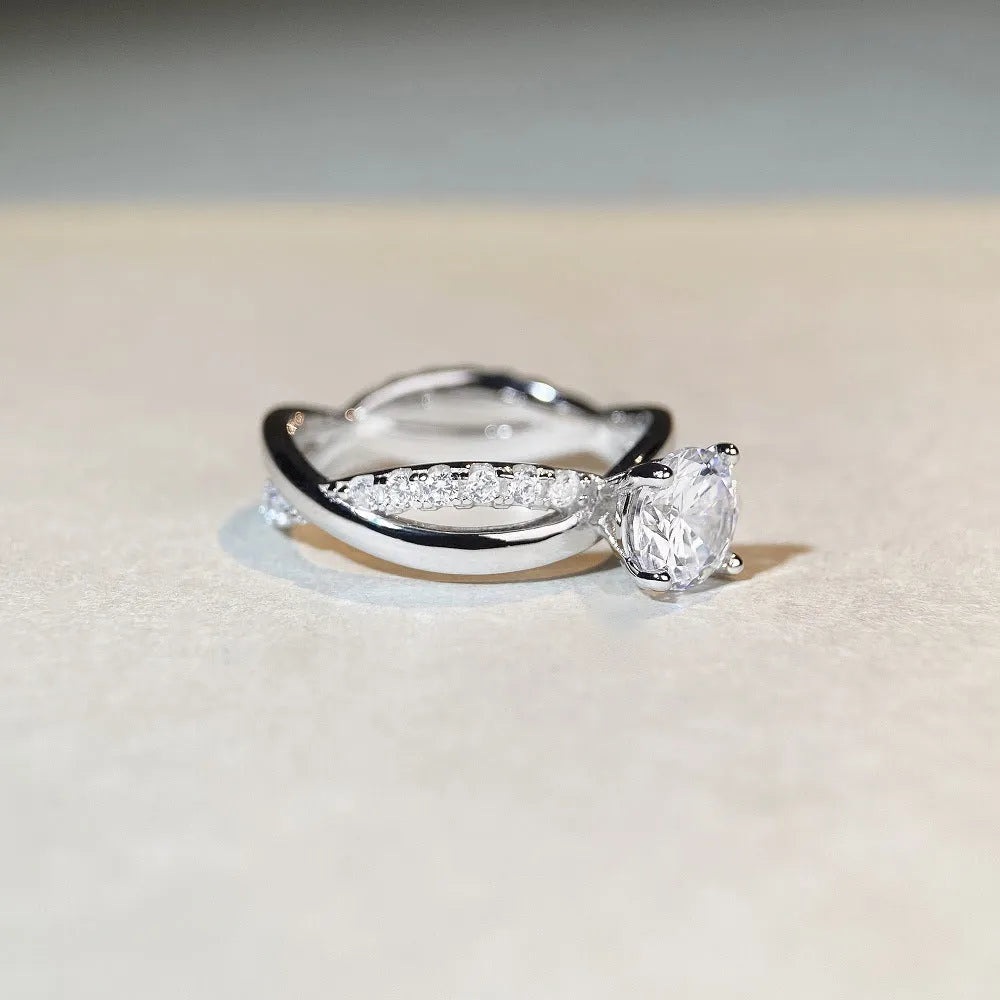 Close-up of a twisted sterling silver band moissanite ring with a four-claw setting and geometric lines.