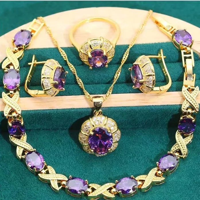 18k gold plated jewellery set with blue synthetic cubic zirconia stones, showing necklace, earrings, ring, and bracelet.