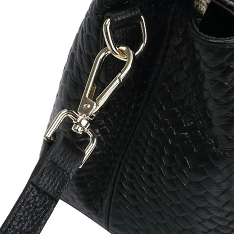 Black genuine leather woven crossbody bag with embossed finish, soft carry handle, and single shoulder strap.