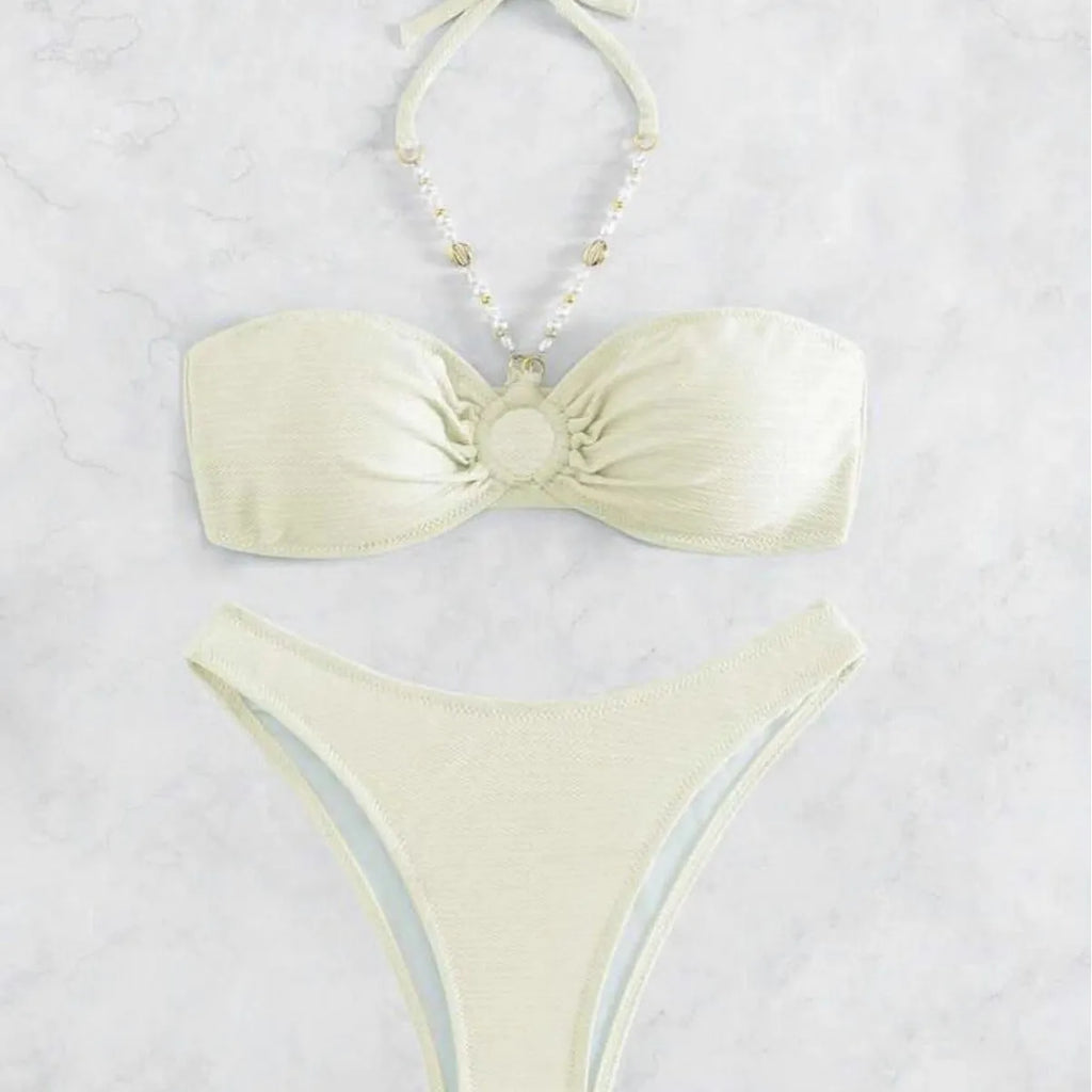 Women's halter-neck bikini swimwear set in a solid colour, shown on a model.