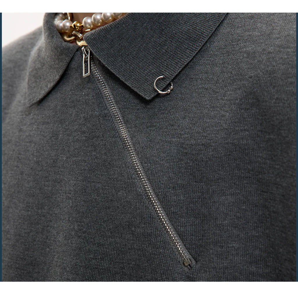 Man modelling a slim-fit black knitted polo shirt with an angled diagonal zipper and a lapel collar.