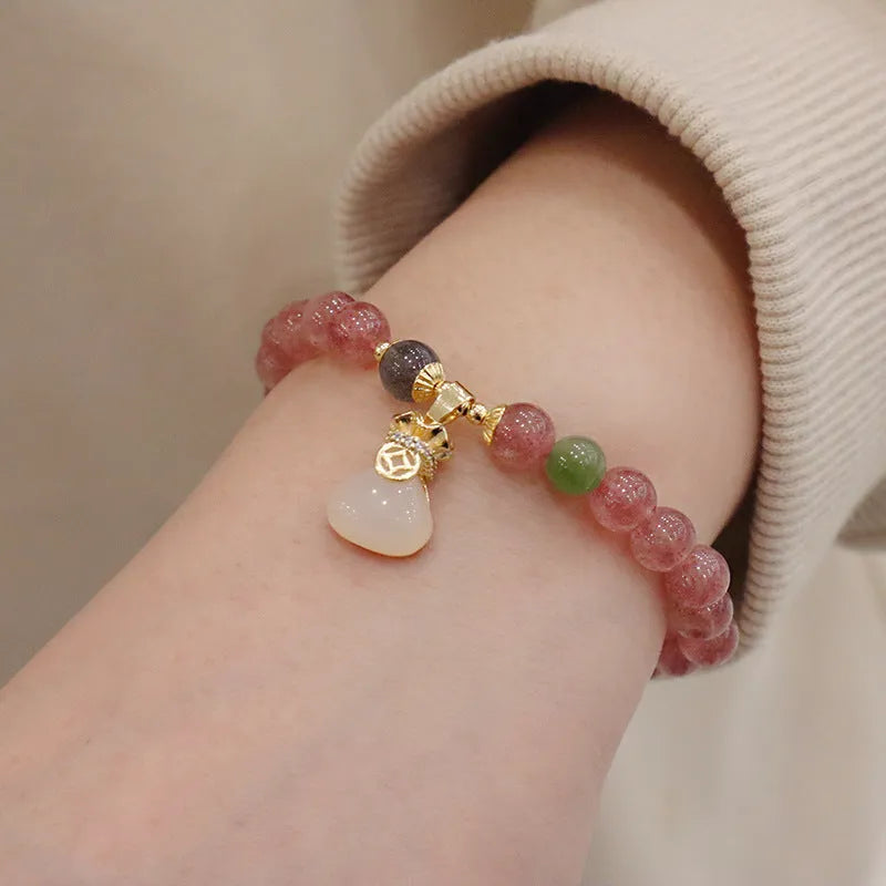 Women's strawberry quartz bracelet with geometric charm, purse charm, and safety buckle.