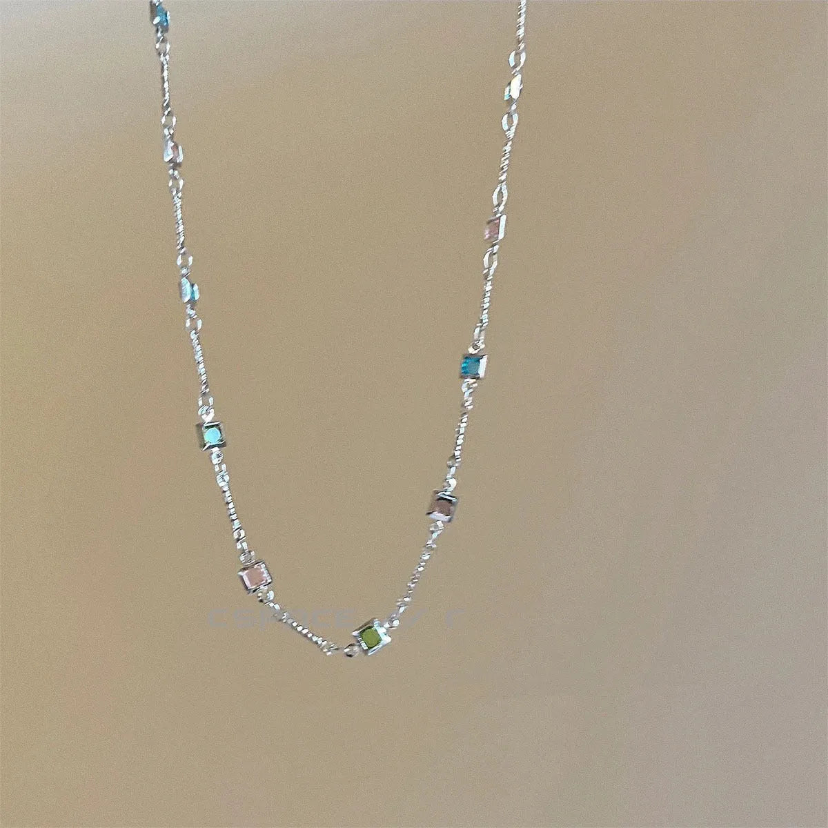 Square colour geometric clavicle chain necklace with artificial crystal details in gold tone.