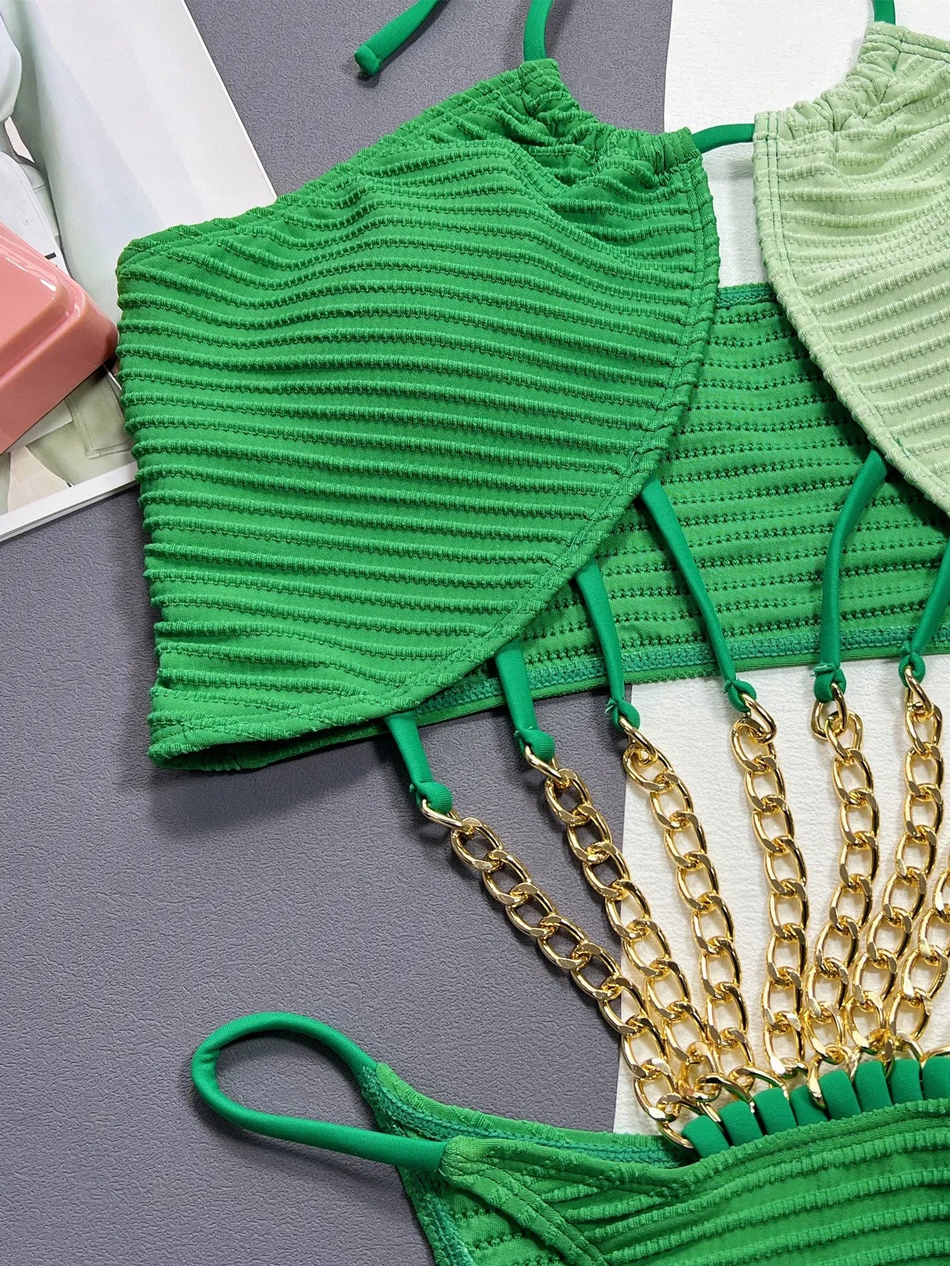 Green women's one-piece swimsuit with hollow out design on a mannequin, showing front and back views.