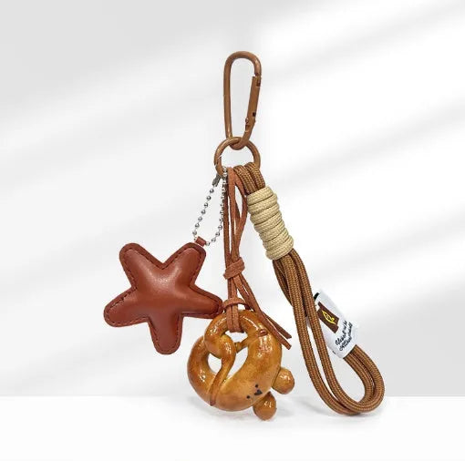 Handmade soda bread style handbag pendant with brown strap showing cartoon baked goods design