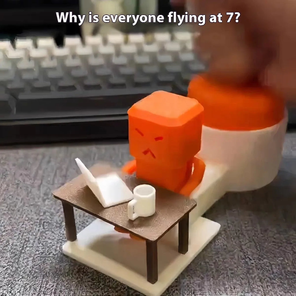 Orange plastic Take and Vent table-turning decompression toy on a desk