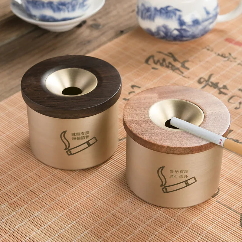 Brass ashtray with wooden lid featuring centre hole design