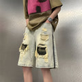 Men's yellow camouflage denim shorts with distressed rips and straight leg cut