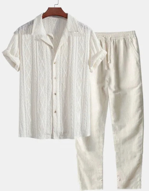 Man wearing a loose light blue short sleeve shirt and matching trousers, a milk silk casual summer suit.