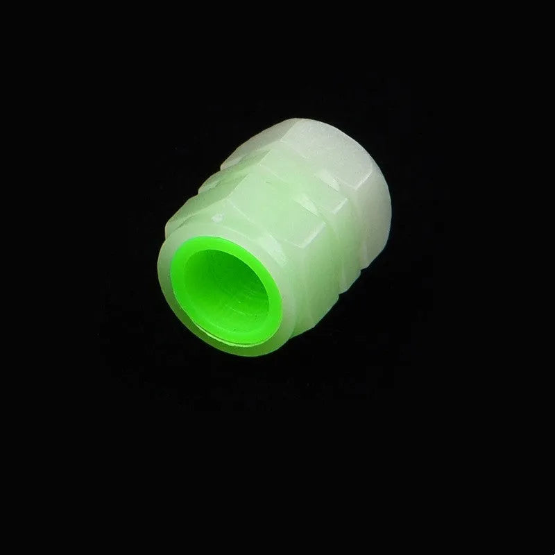 Pack of four black rubber car valve caps with luminous glow-in-the-dark tops.