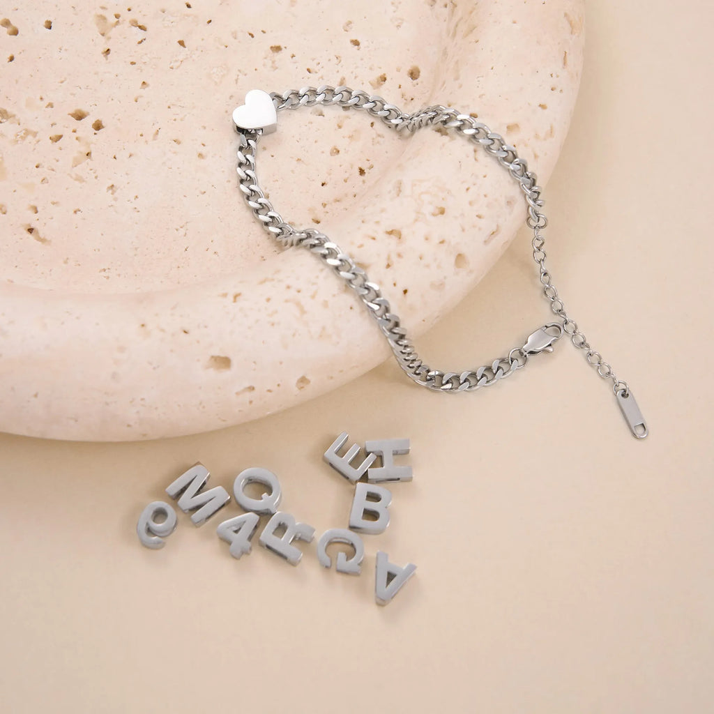 A gold and a silver titanium steel necklace with letter and number pendants on a 40.5cm chain.