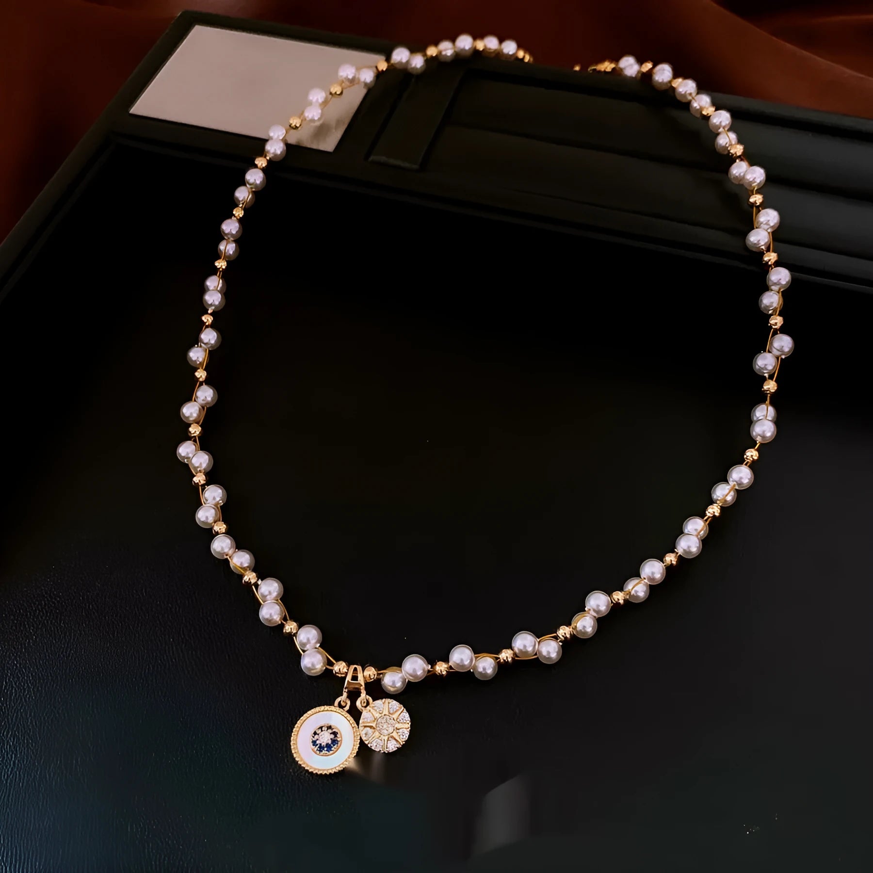 Gold electroplated women's necklace with round zircon and imitation pearl pendant on an adjustable clavicle chain.