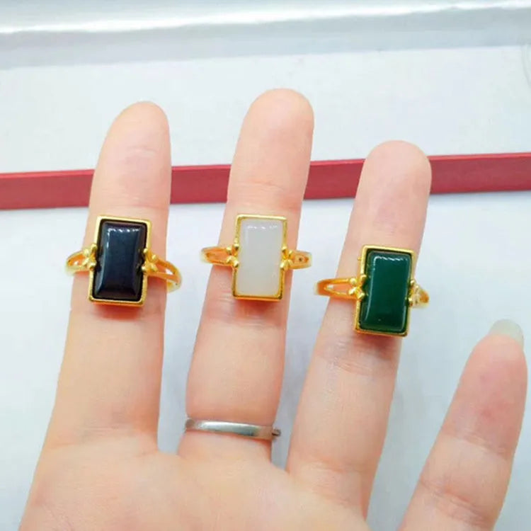 Adjustable brass gold-plated ring with a central electroplated gemstone, shown in black, green, and white colour options.