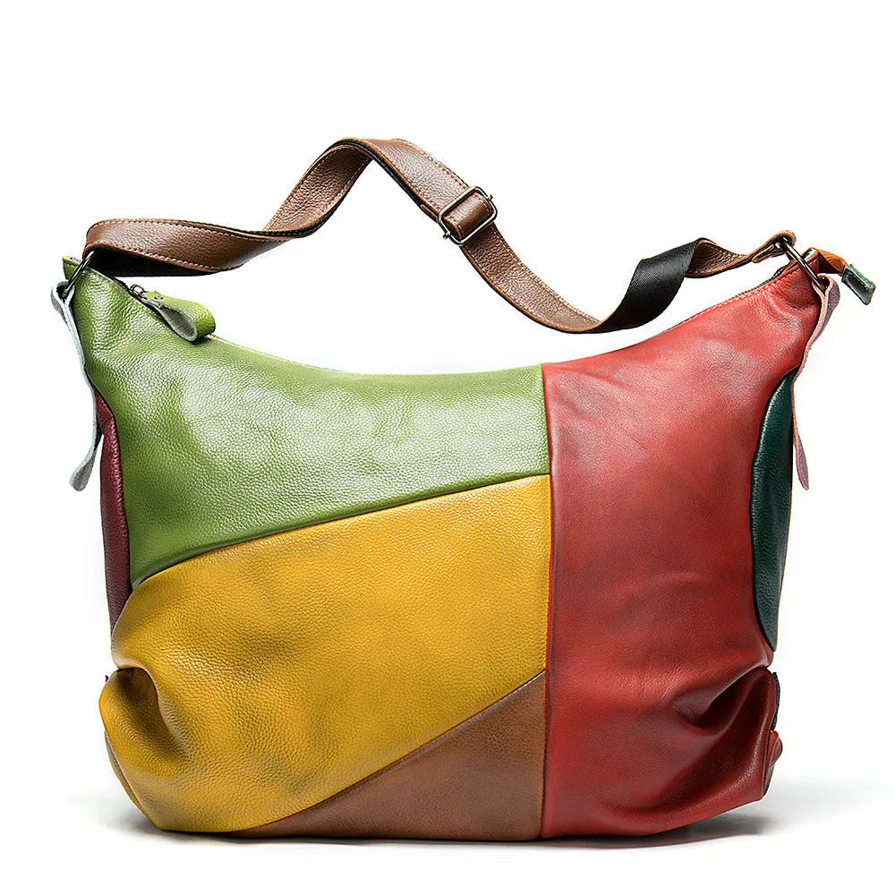 Brown cowhide leather crossbody shoulder travel bag with stitching detail, shown with a laptop and magazine inside.