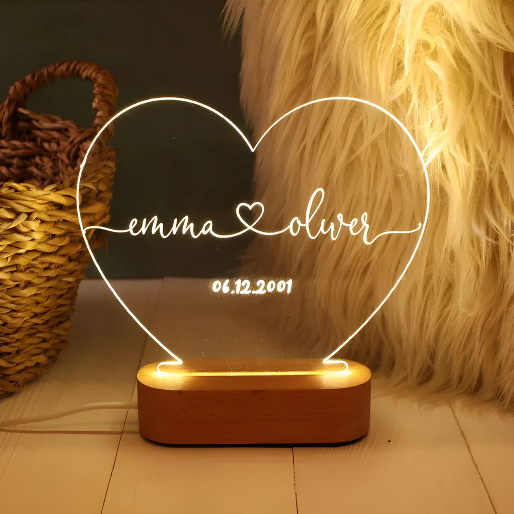 Personalised acrylic night light showing illuminated custom names and date on a transparent panel.