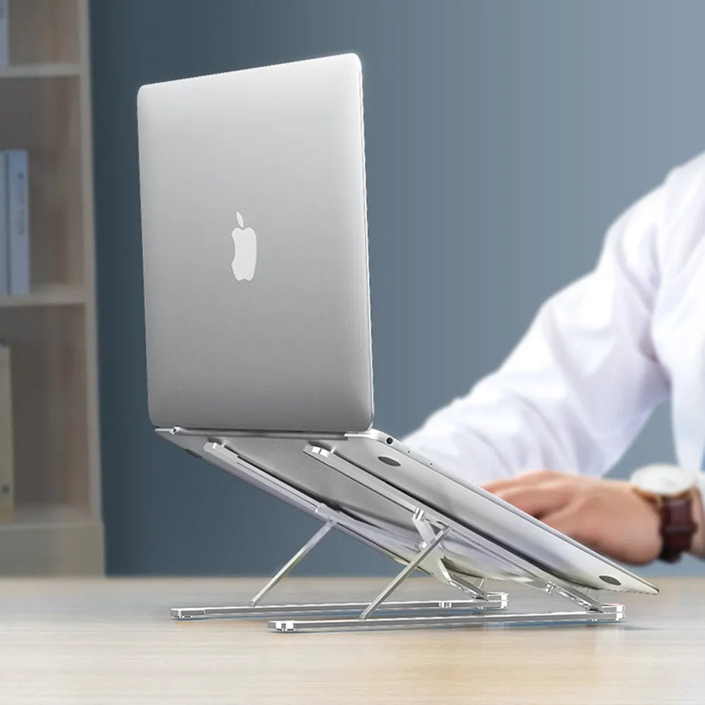 Aluminum alloy laptop stand in silver colour, folded to show its slim profile next to a 15-inch laptop.