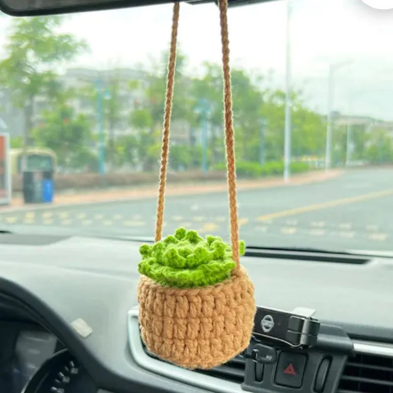 Green and white knitted wool car plant decoration basket with white hanging cord.