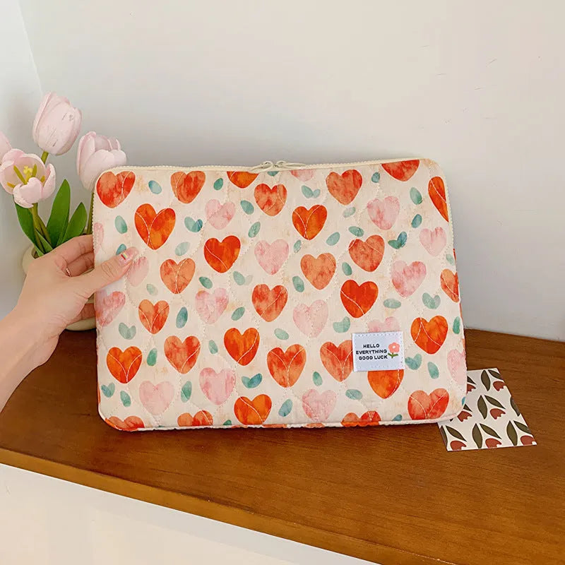 Green floral print cloth laptop bag shown next to red heart and pink floral design options.