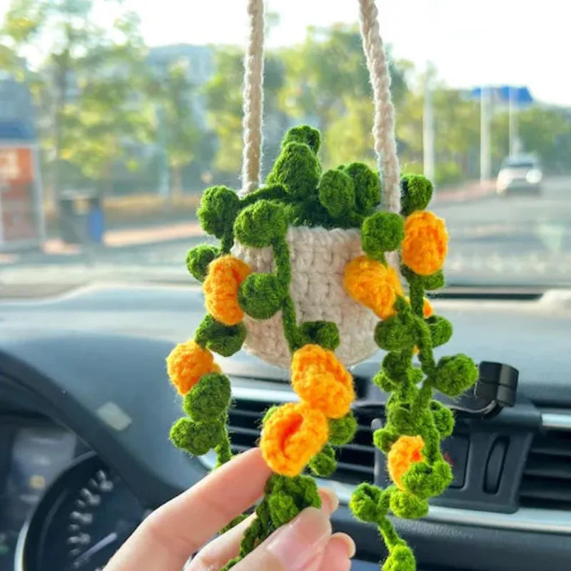 Green and white knitted wool car plant decoration basket with white hanging cord.