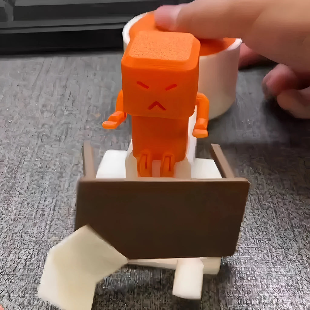 Orange plastic Take and Vent table-turning decompression toy on a desk