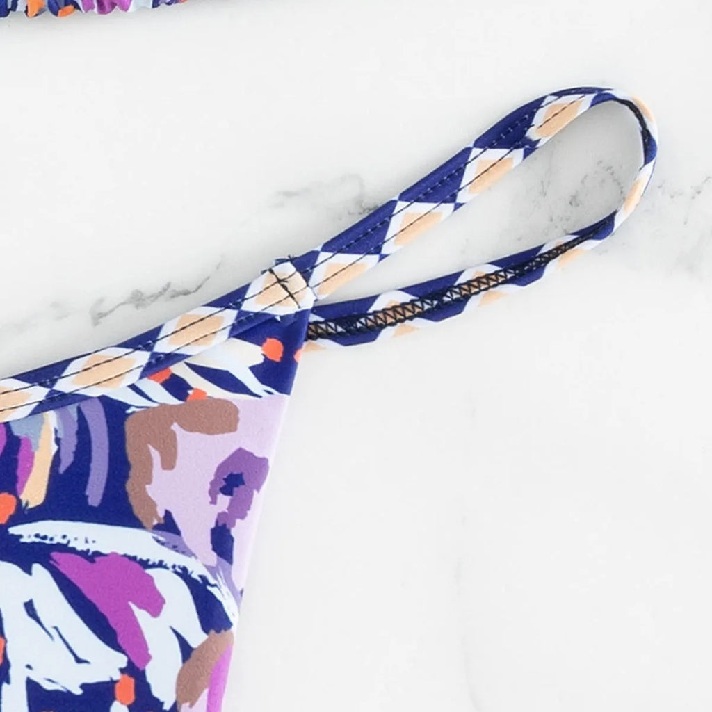 Women's floral print polyester bikini with triangle top and split-side brief bottoms.
