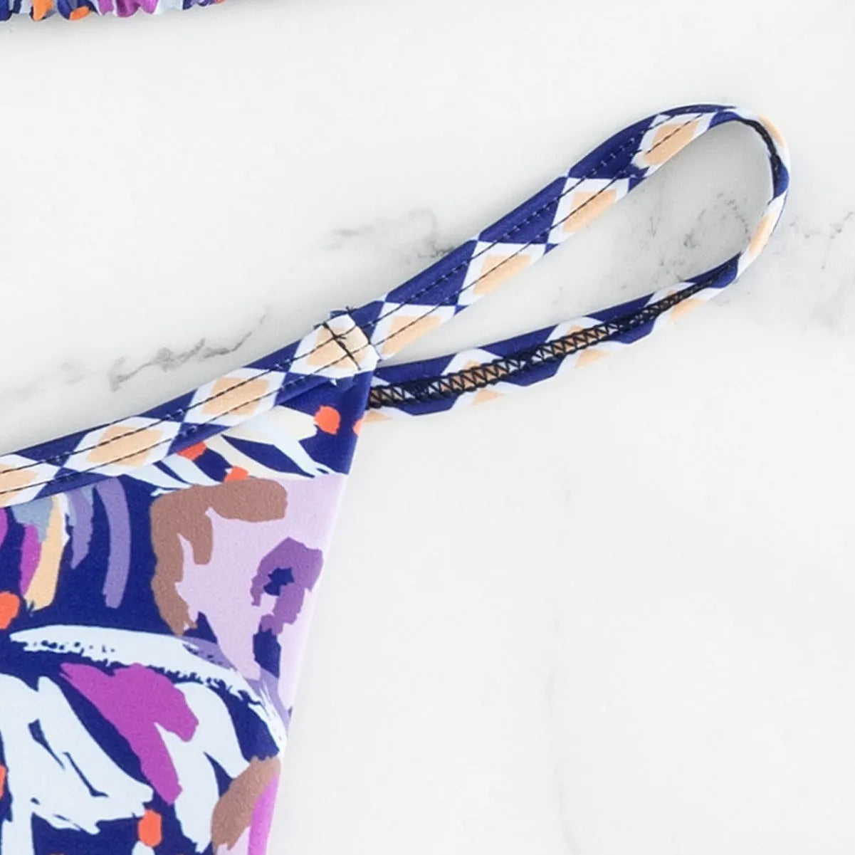 Women's floral print polyester bikini with triangle top and split-side brief bottoms.