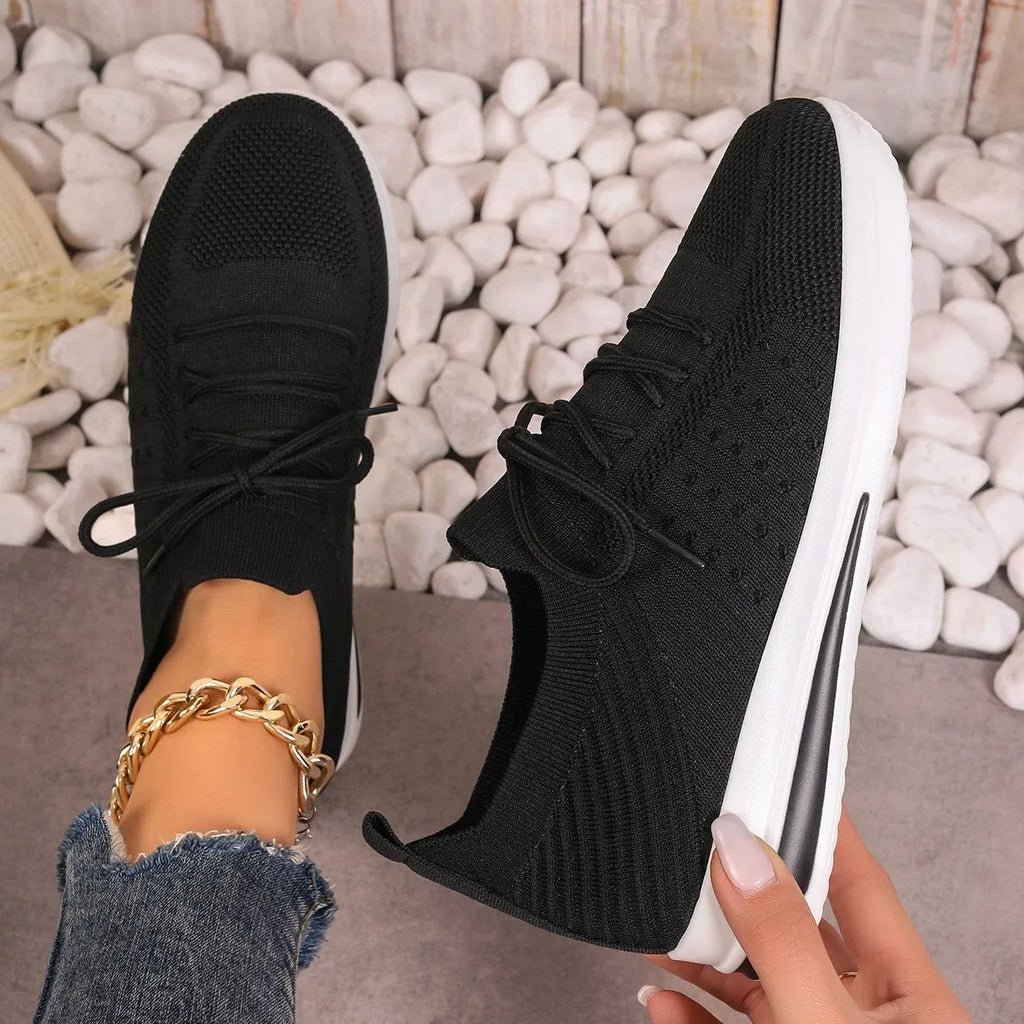 Women's low-top casual sneakers in black, blue, and red with a fly-knit style PU upper and lace-up front.