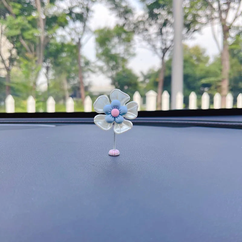 Small colourful plastic swing car decoration in blue, green, pink, purple, and yellow options.