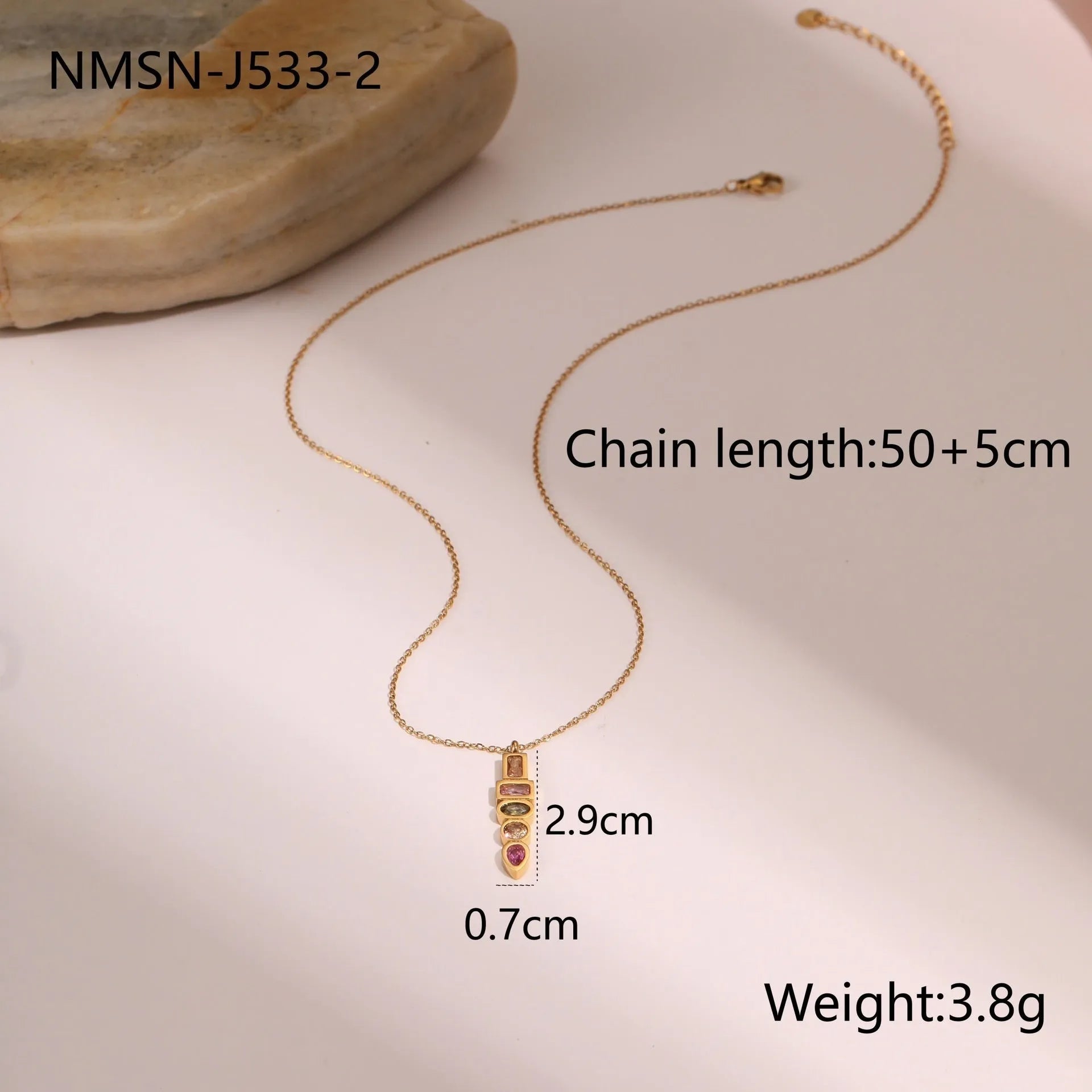 Geometric gold plated jewellery set on display showing drop necklace, U shape necklace, ring, and earrings with zircon accents.