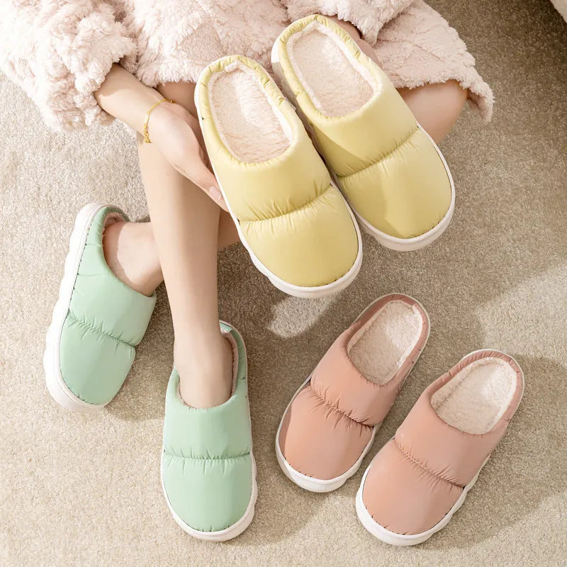 Blue winter indoor slippers with thick rubber sole and plush lining, shown on a hard floor.