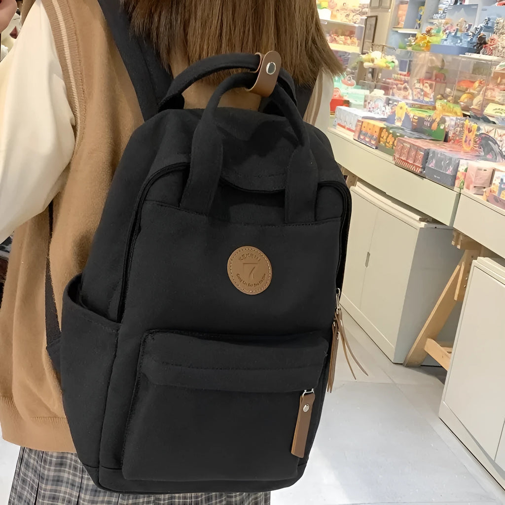Black Oxford cloth backpack with curved shoulder straps and retro sewing thread detailing