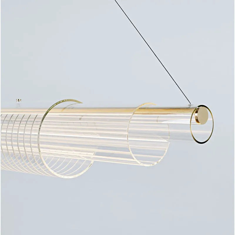 Modern clear glass and iron LED pendant light hanging at three different lengths.