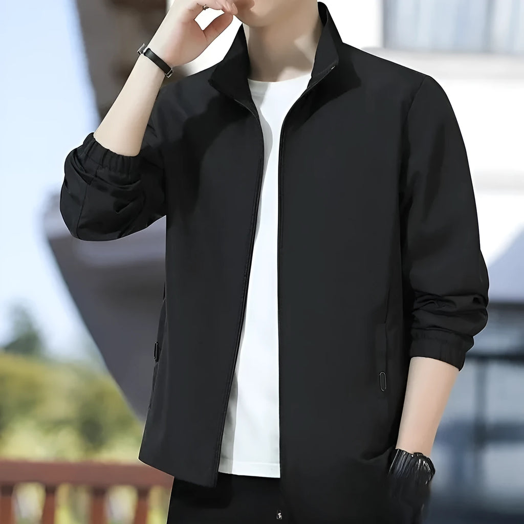 Man wearing a loose-fit black Korean-style autumn jacket with a lapel collar and zipper pockets.