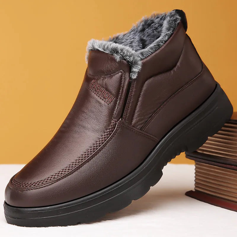 Men's black fleece-lined slip-on winter shoes with a rubber sole on a grey background.