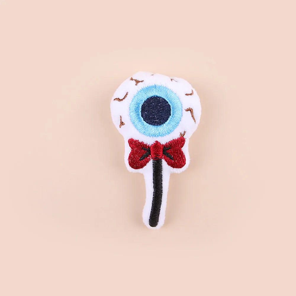 Small colourful plush cat teaser toy with candy, eyes and skull attachments