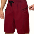 Man wearing solid colour quick-dry polyester beach shorts in a straight-leg style by the water.