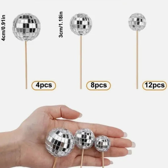 Glass disco ball cake decoration on wooden stick, showing reflective surface.