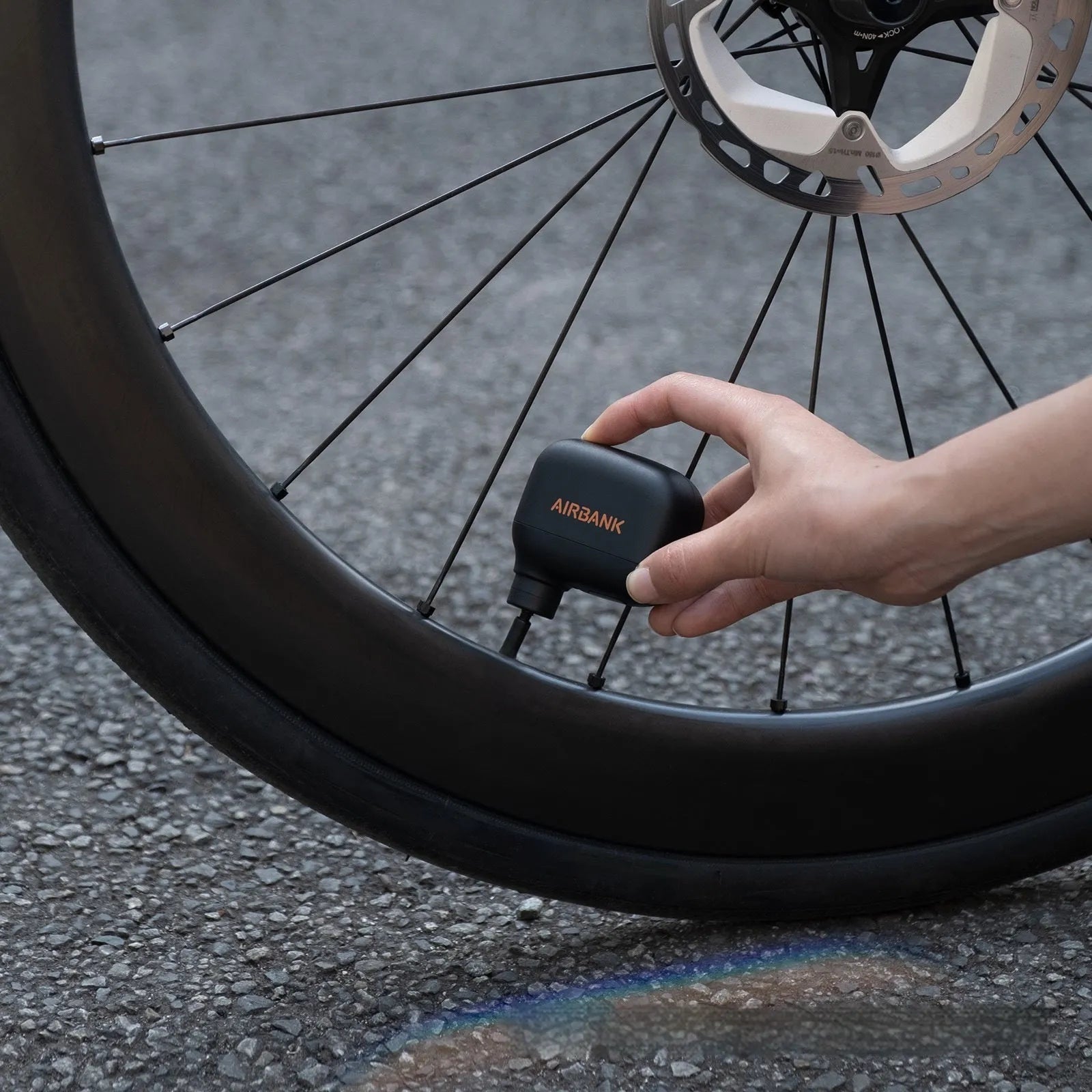 Black mini electric bike pump with USB charging cable and waterproof storage bag for portable bicycle tyre inflation