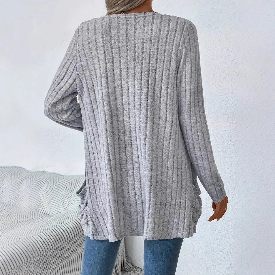 A solid colour long sleeve cardigan with pockets, shown in a loose fit on a model.