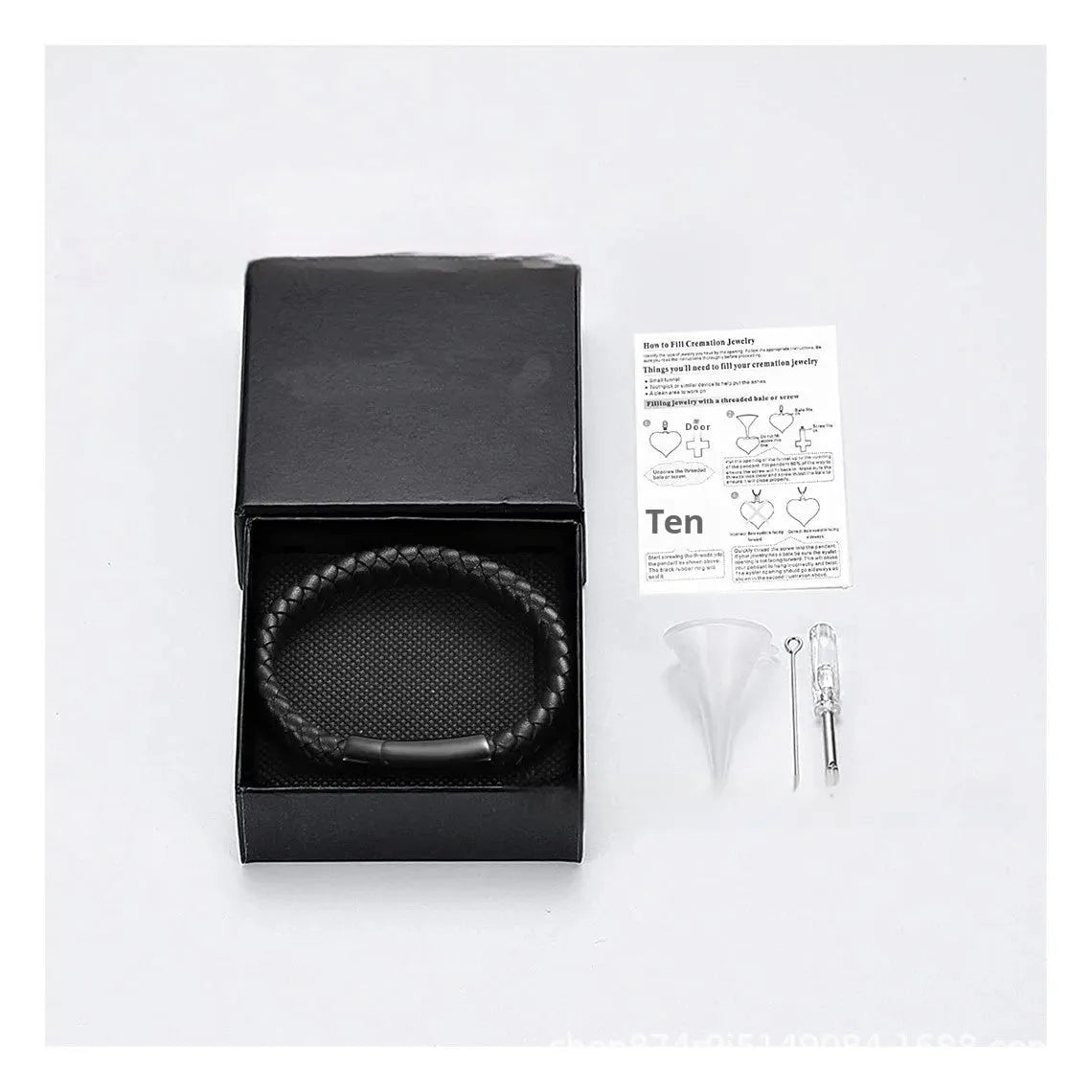 Black leather bracelet with a small stainless steel casket charm, shown in a gift box.