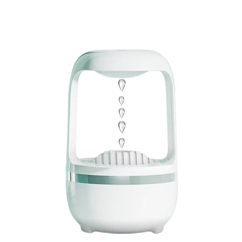 White anti-gravity humidifier with upward-flowing water droplets on a desk