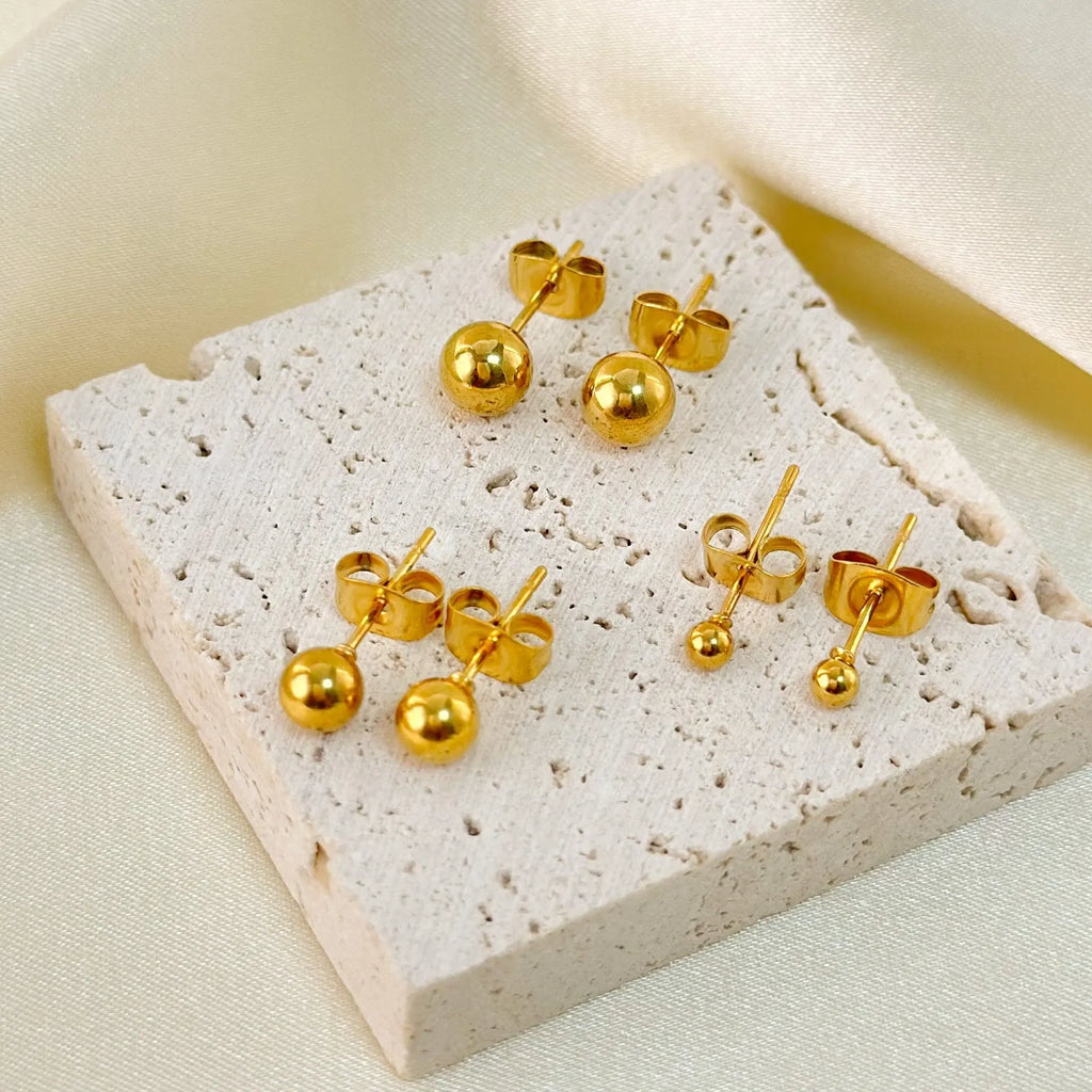 Stainless steel 18K gold ball stud earrings in round geometric design on simple stud posts.