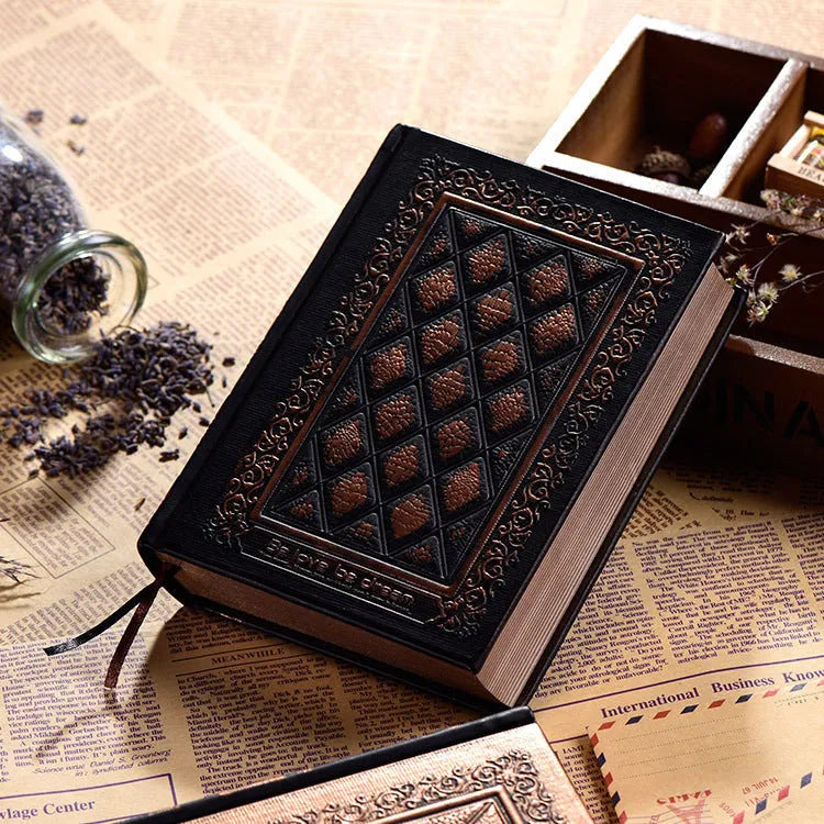 A5 hardback notebook with embossed faux leather cover in bronze colour, shown open on a table.