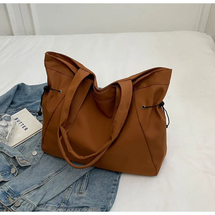 Soft Oxford cloth folding tote bag shown in a choice of five colours on a plain background.