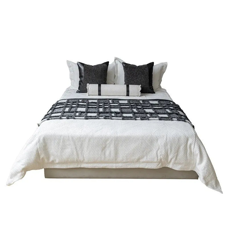 Modern minimalist bed runner set with blanket, pillowcase and leather round pillow on bed