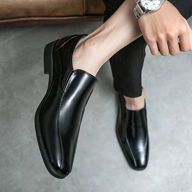 Men's black pointed patent leather casual shoes with flat rubber sole and low tube sock.